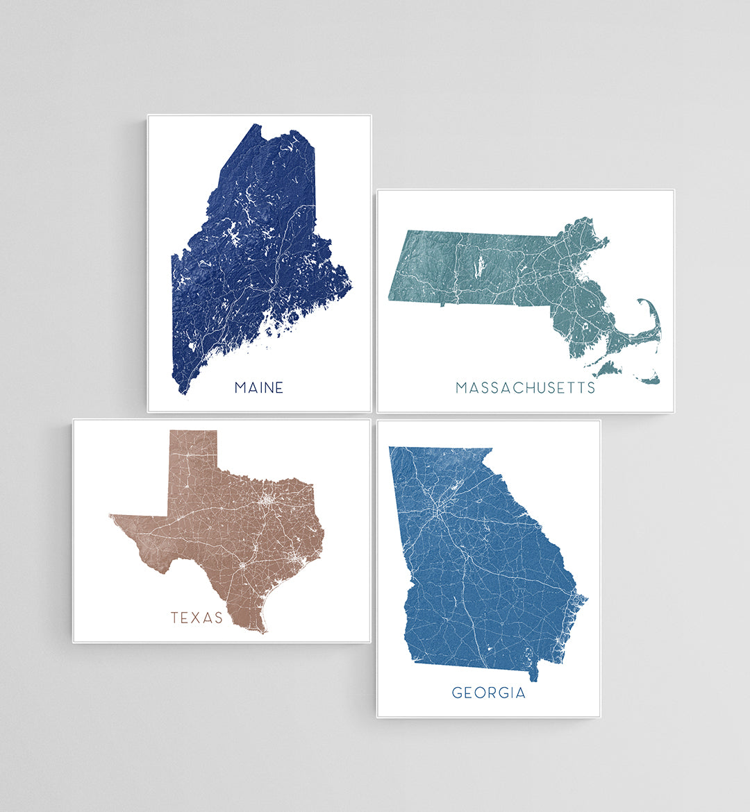 Four state map prints displayed together, featuring Maine, Massachusetts, Texas, and Georgia in different colours.