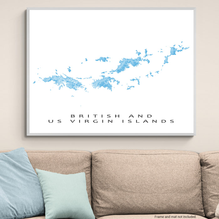 Framed map of British and US Virgin Islands on a wall above a beige sofa with light blue pillows.