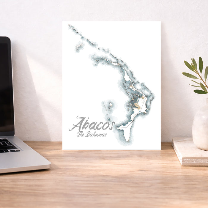 Map of Abacos, The Bahamas on a desk with a laptop and plant.