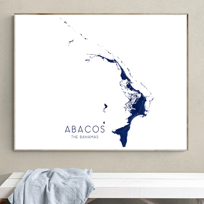 Framed map of Abacos, The Bahamas on a wall above a white bench.