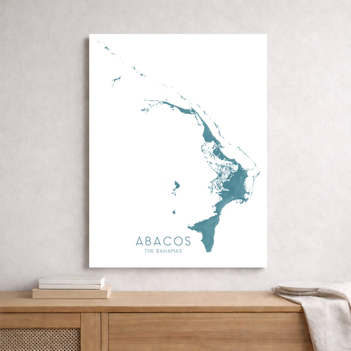 Map of Abacos, The Bahamas on a white wall above a wooden shelf.
