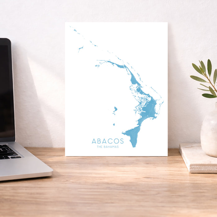 Map of Abacos, The Bahamas on a desk with a laptop and plant.