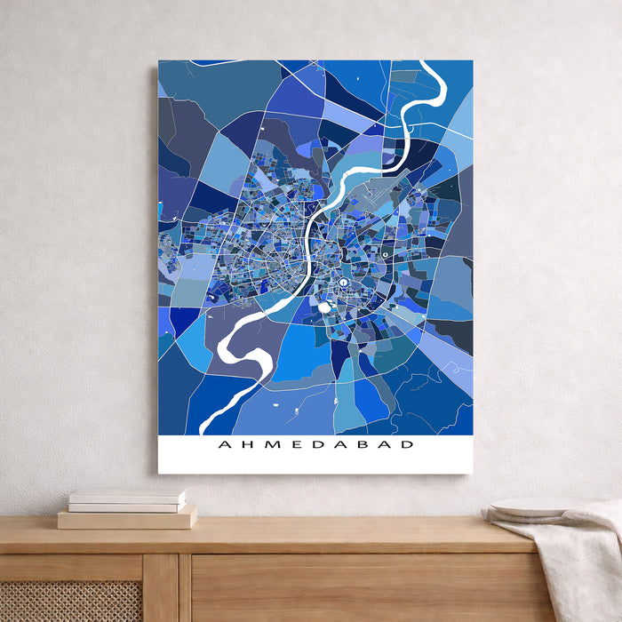 Map of Ahmedabad in blue tones on a white wall above a wooden surface.