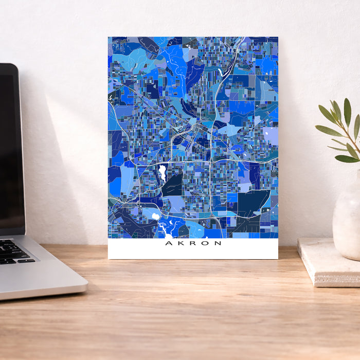 Map of Akron on a desk with a laptop and plant
