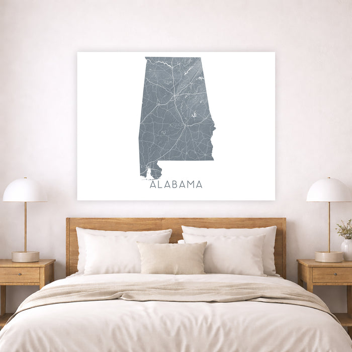 Map of Alabama on a wall above a bed in a bedroom setting