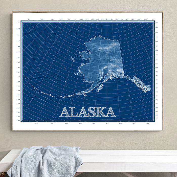 Framed blueprint-style map of Alaska on a wall.