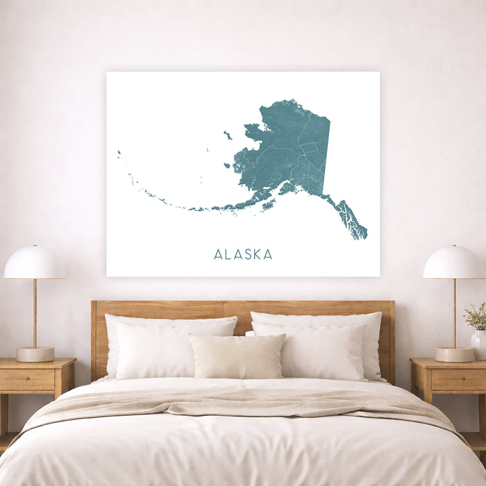 Map of Alaska on a wall above a bed in a bedroom