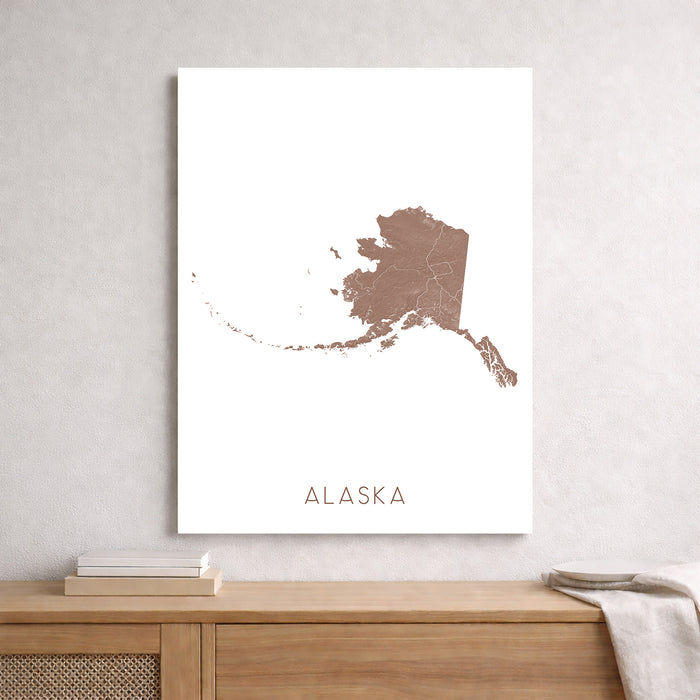 Map of Alaska on a white background, framed and leaning against a light gray wall.
