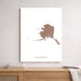 Map of Alaska on a white background, framed and leaning against a light gray wall.