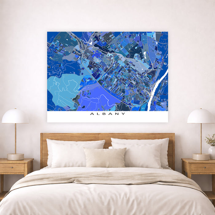 Map of Albany on a wall above a bed with nightstands and lamps.
