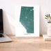 Map of Alberta on a desk with a laptop and plant