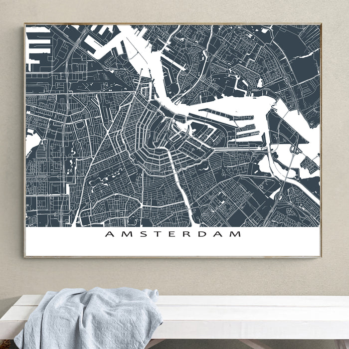 Framed map of Amsterdam on a wall above a white bench.