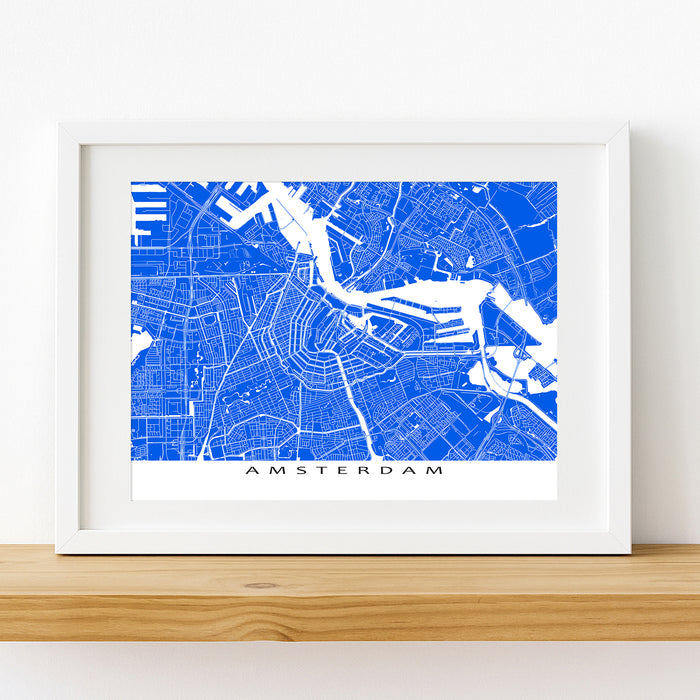Framed map of Amsterdam on a wooden shelf with a white background