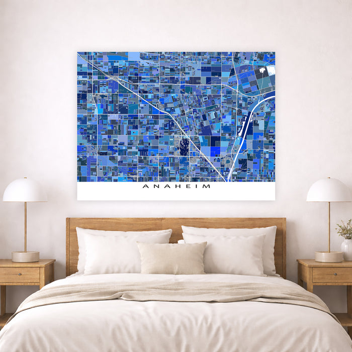 Blue mosaic map of Anaheim on a wall above a bed with wooden headboard and nightstands.
