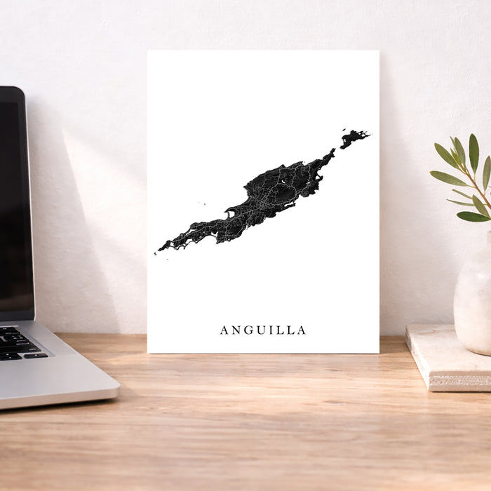 Map of Anguilla on a desk with a laptop and plant