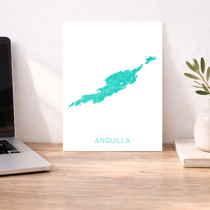 Map of Anguilla on a white background next to a laptop on a wooden desk.