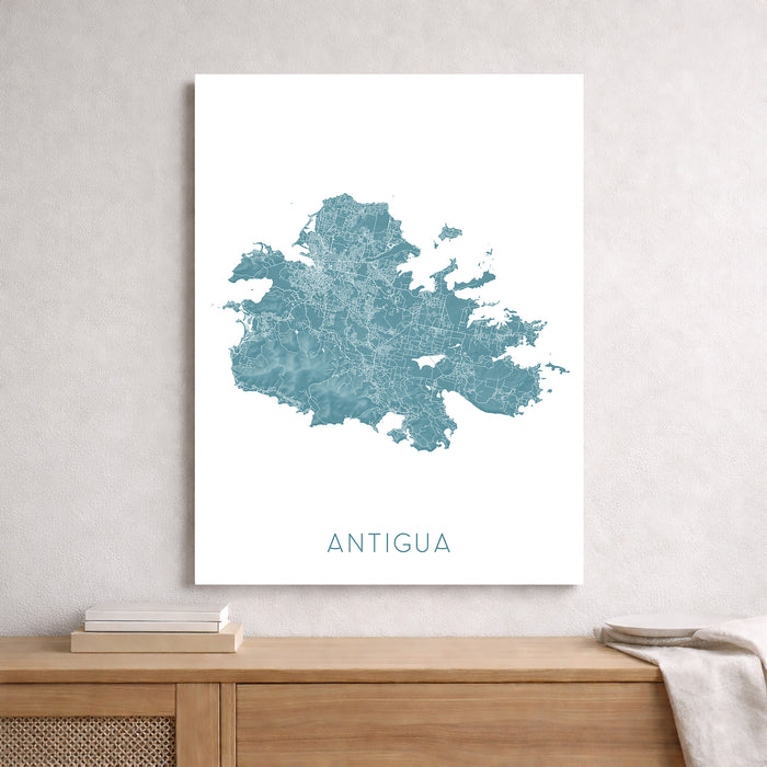 Map of Antigua on a white wall above a wooden shelf.