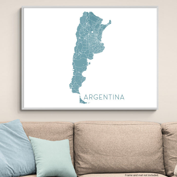 Framed map of Argentina on a wall above a beige sofa with light blue pillows.