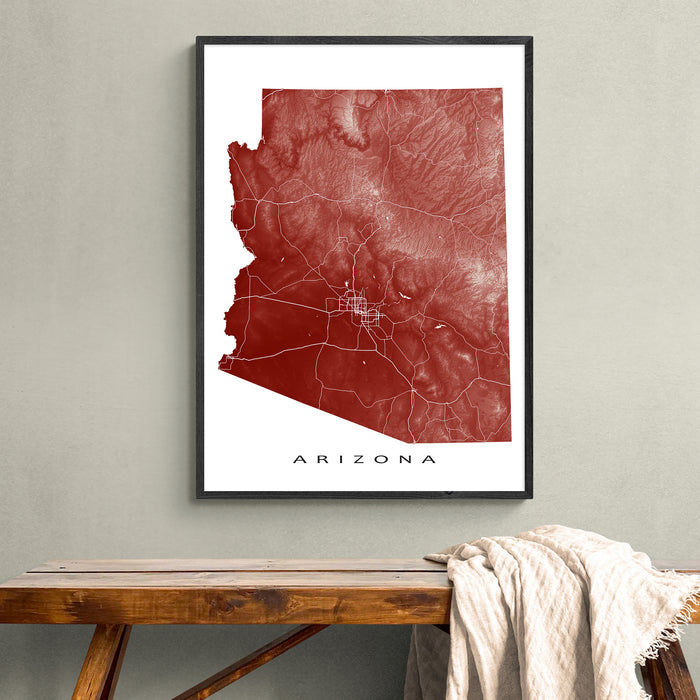 Framed map of Arizona on a wall above a wooden bench.