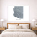 Framed map of Arizona on a wall above a bed in a bedroom.