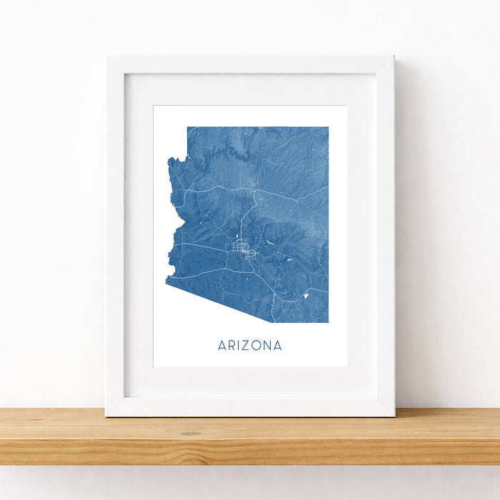Framed map of Arizona on a wooden shelf with a white background