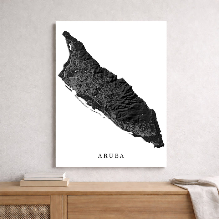 Map of Aruba on a white wall above a wooden cabinet.