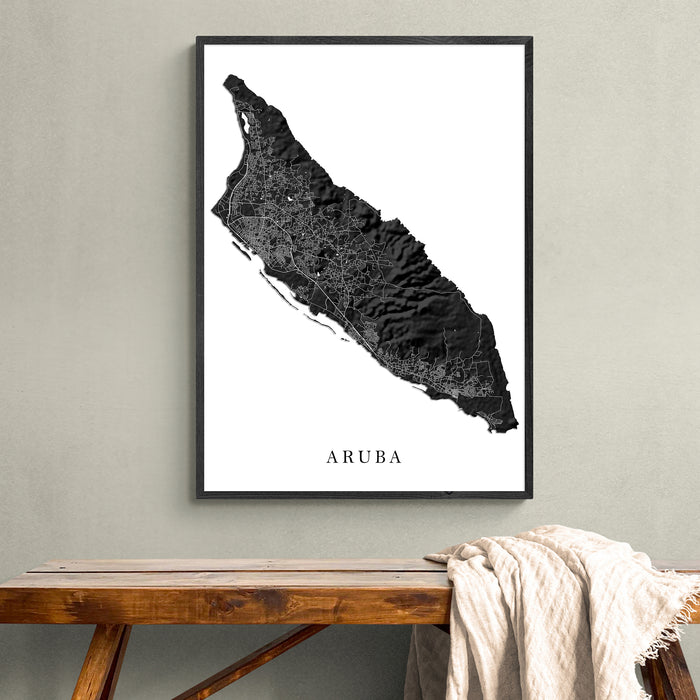 Framed map of Aruba on a wall above a wooden bench.