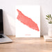 Map of Aruba on a white background next to a laptop on a wooden desk.