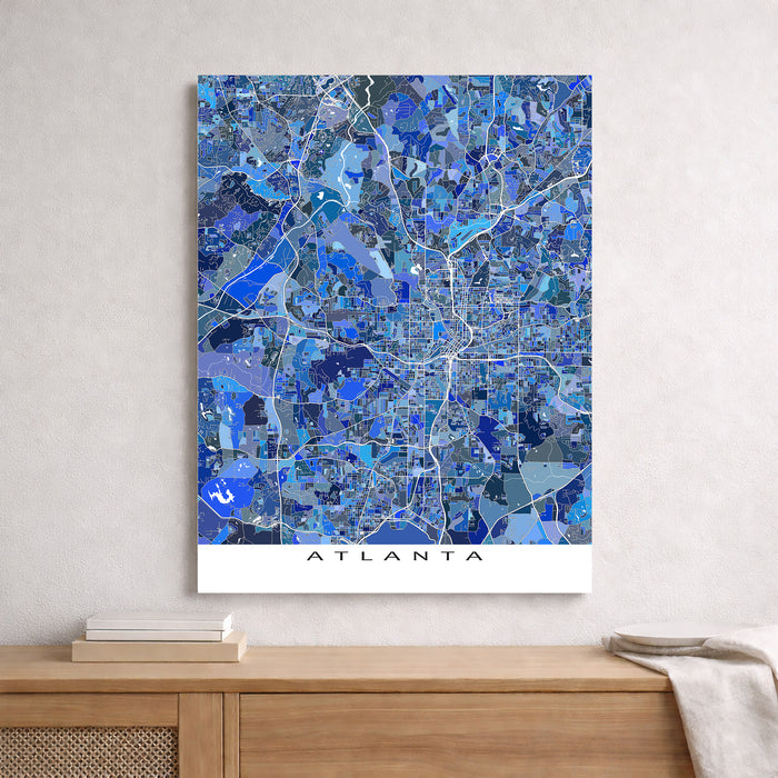 Map of Atlanta in blue tones on a white wall above a wooden shelf.