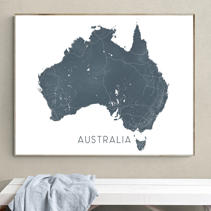Framed map of Australia on a wall above a white bench.