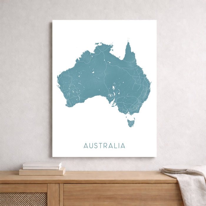 Map of Australia on a white wall above a wooden shelf.