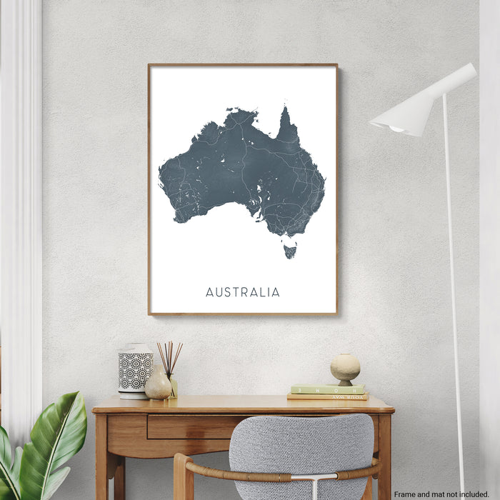 Map of Australia on a wall above a desk with decor items.