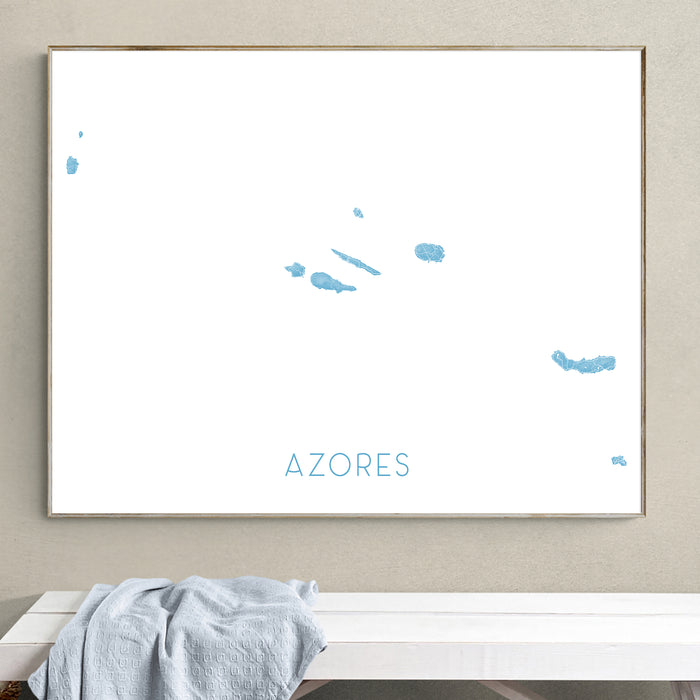 Framed map of the Azores on a wall above a white bench with a gray blanket.