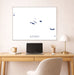 Framed map of Azores above a desk with a laptop and lamp.