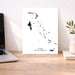 Map of The Bahamas on a white background next to a laptop on a wooden desk.