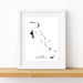 Framed black and white map of The Bahamas on a white wall.
