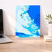 Map of the Bahamas on a wall above a desk with a laptop and plant.
