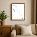 Framed map of The Bahamas on a wall above a beige sofa with a plant beside it.