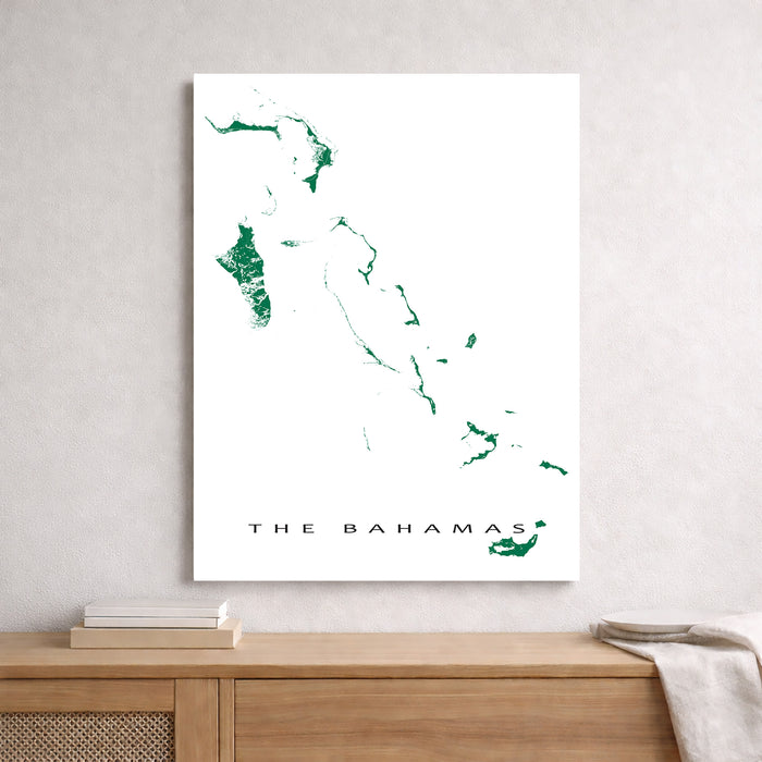 Map of The Bahamas on a white wall above a wooden shelf.
