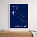 Framed map of The Bahamas on a blue background, displayed on a wooden surface with a neutral wall.