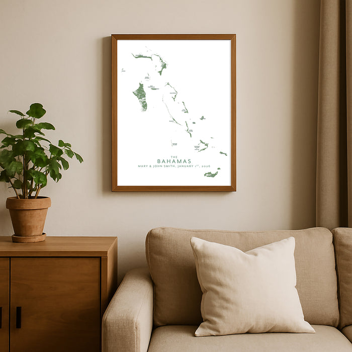 Framed map of the Bahamas on a wall above a beige sofa with a plant beside it.