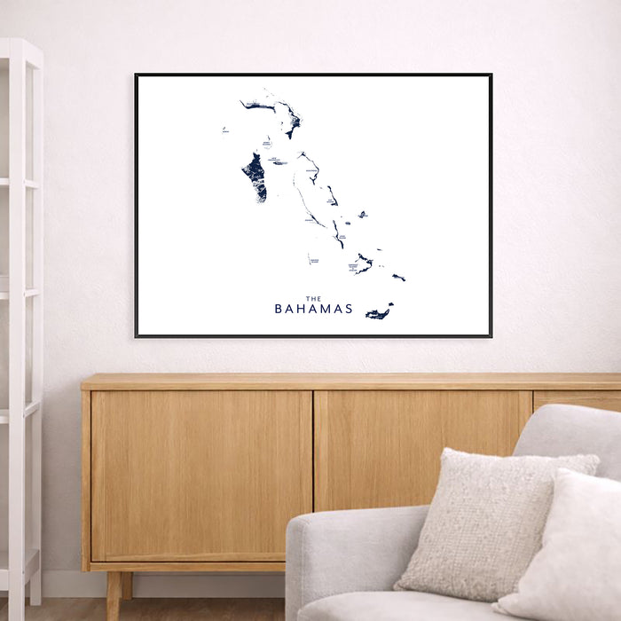 Framed map of The Bahamas on a wall above a wooden cabinet and sofa.