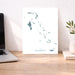Map of The Bahamas on a desk with a laptop and plant