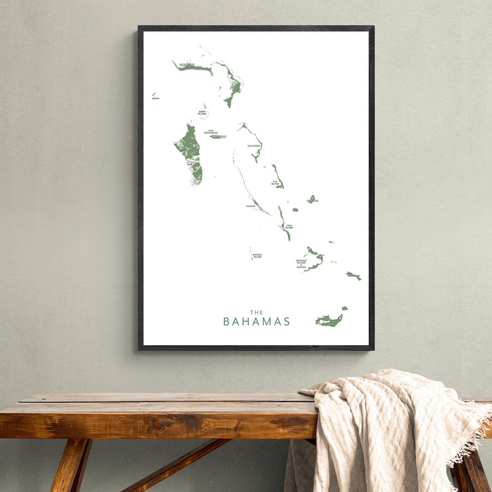 Framed map of The Bahamas on a wall above a wooden bench.