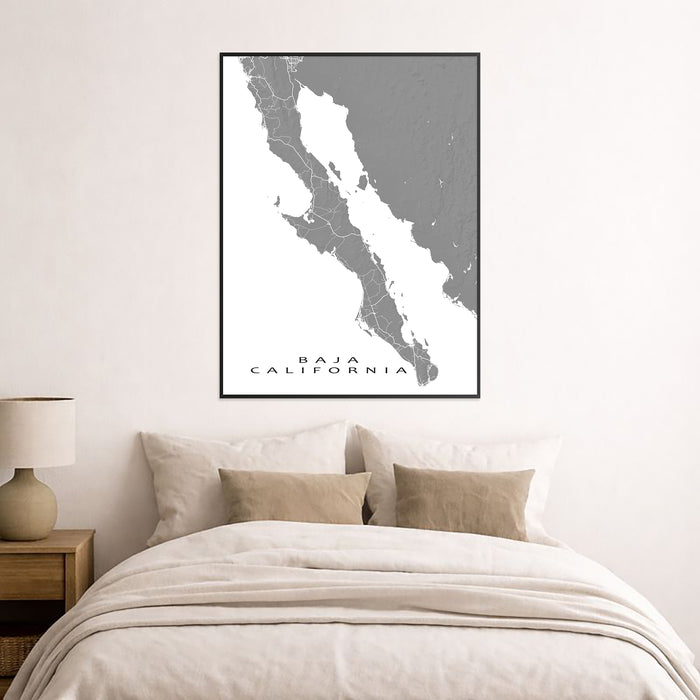 Framed map of Baja California on a wall above a bed.