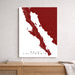Map of Baja California in red and white on a wall above a wooden shelf.
