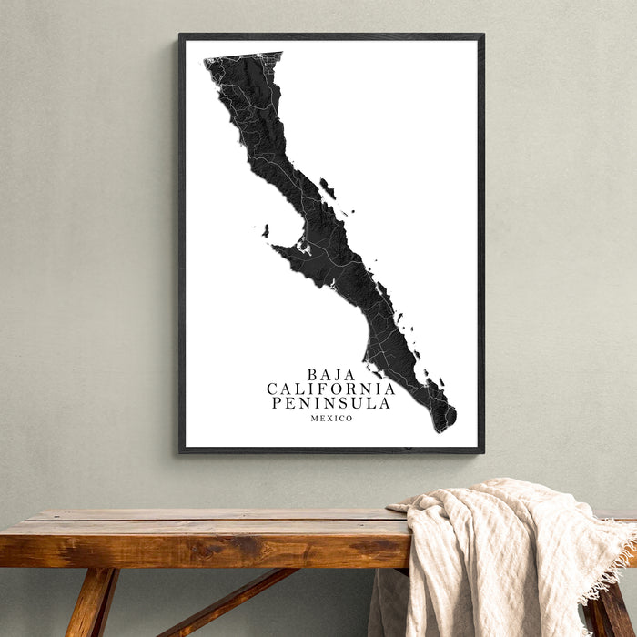 Framed map of Baja California Peninsula on a wall above a wooden bench.
