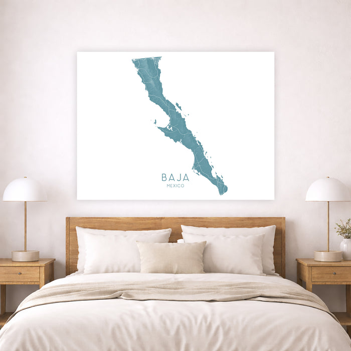 Map of Baja California on a wall above a bed in a bedroom.