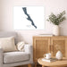 Living room with a map of Baja California, a vase with plants, and a wooden cabinet.