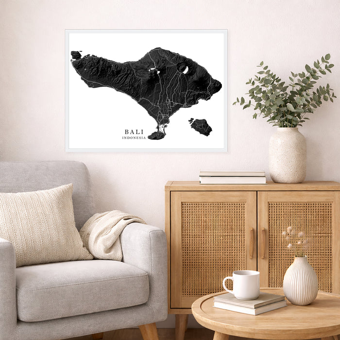 Framed map of Bali on a wall above a sofa in a living room.